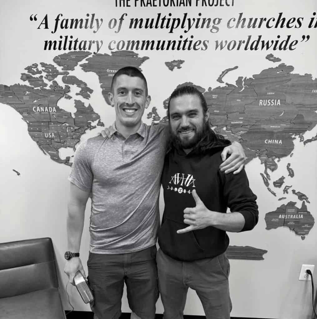 Men smiling in front of world map portraying the locations of the Pillar Churches around the world.